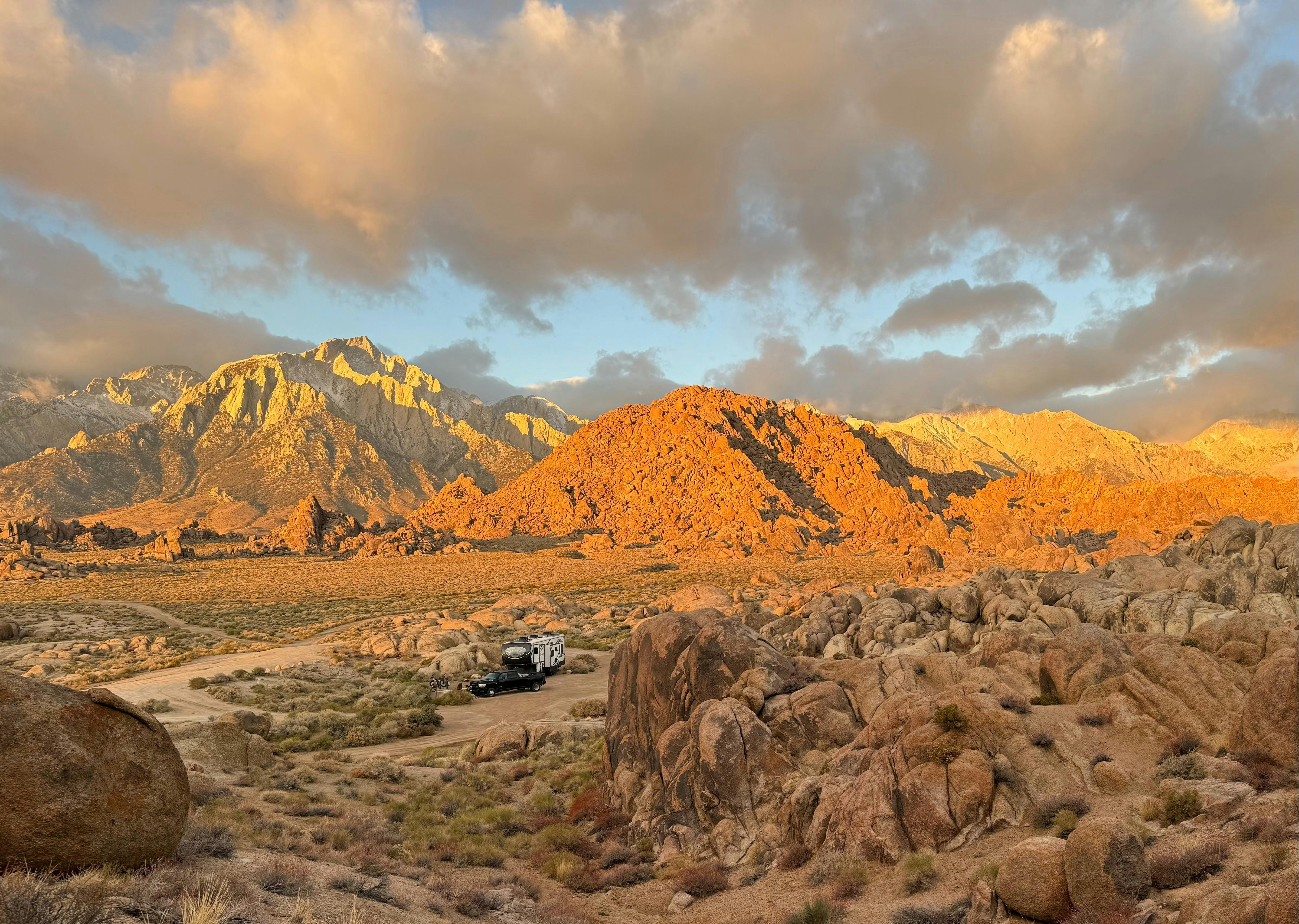 A panoramic desert view at sunset and Melissa and Lucas Lahr's Heartland Torque toy hauler.