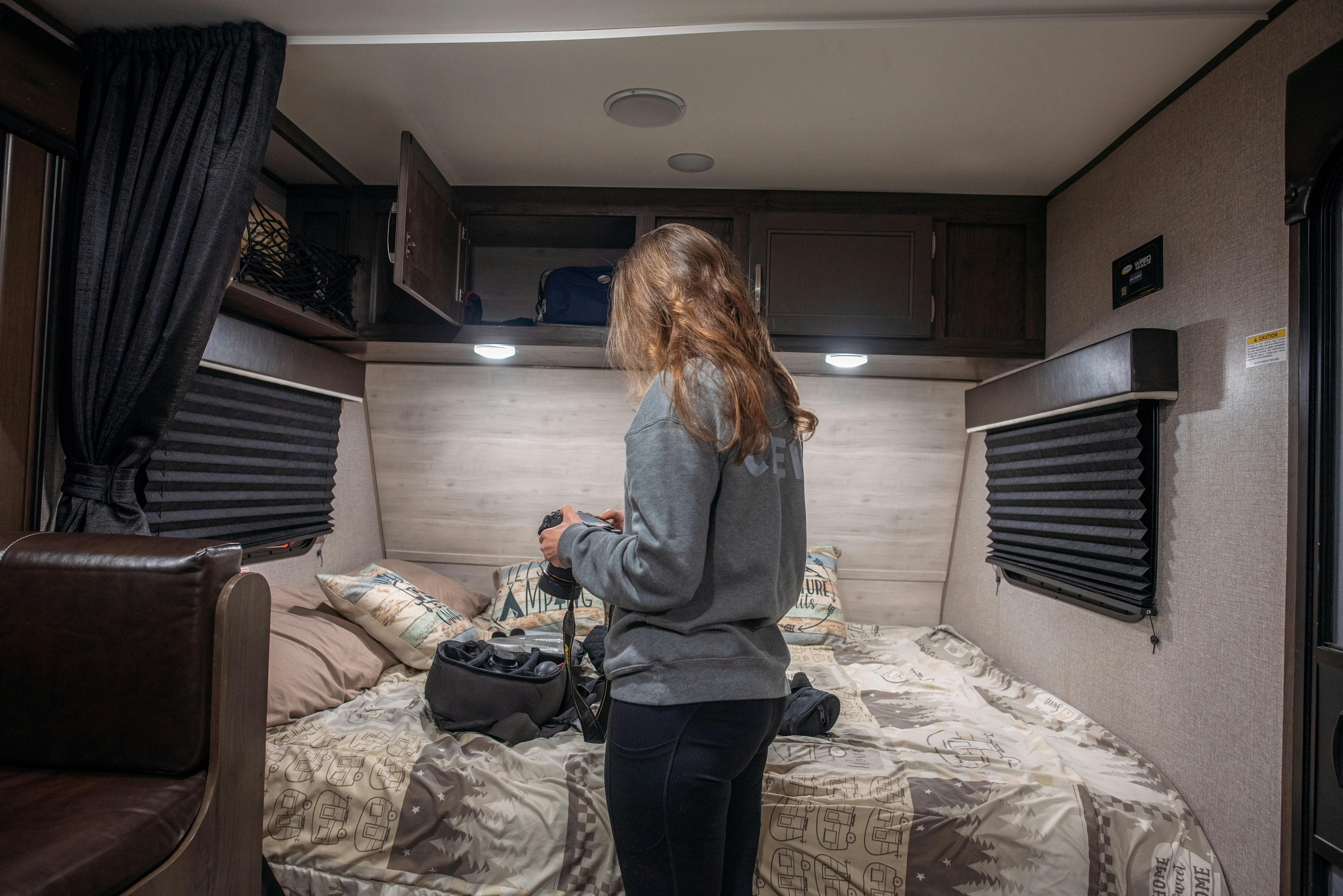 Alison Takacs organizes her camera equipment in the bedroom of her Jayco Jay Flight.