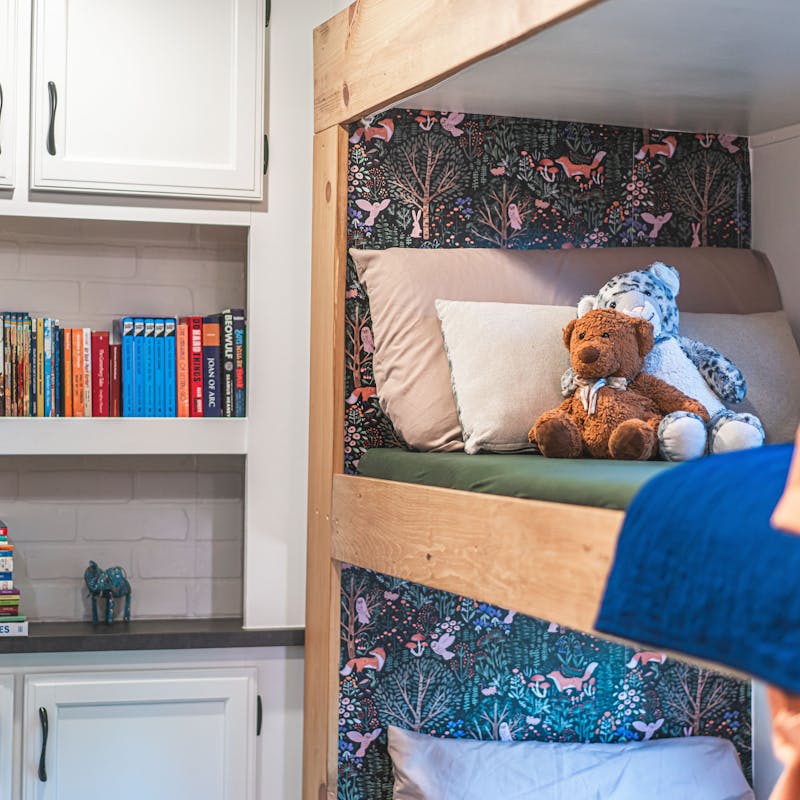 A bookshelf and bunkbeds inside Renee Tilby's Jayco Jay Flight travel trailer.
