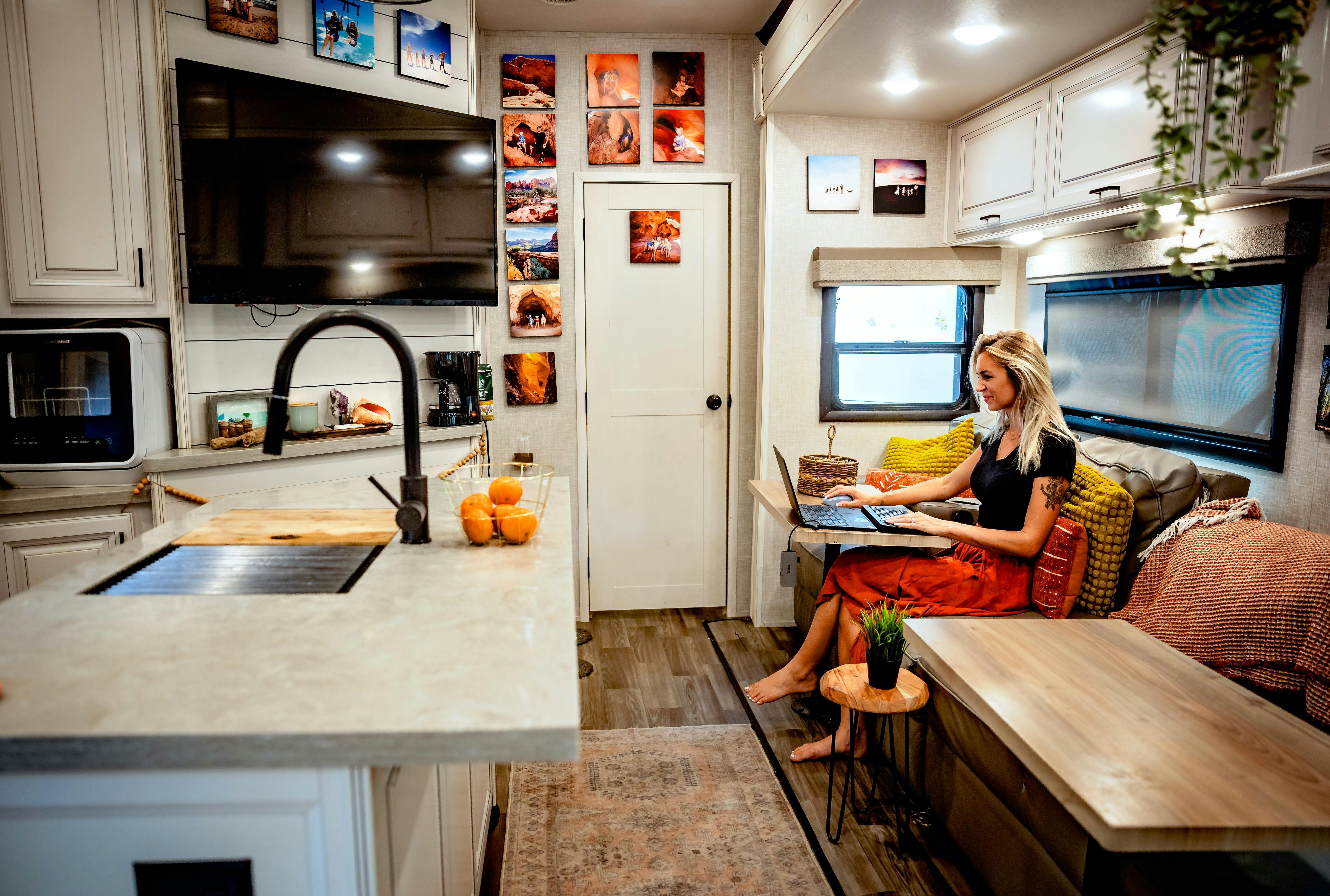 Cassie Bailey on her laptop in her Highland Ridge Open Range fifth wheel.