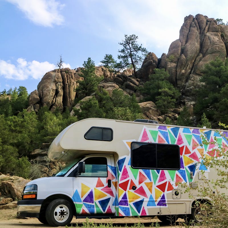 Jason and Dawn's Class C RV parked near large rocks as they boondock.