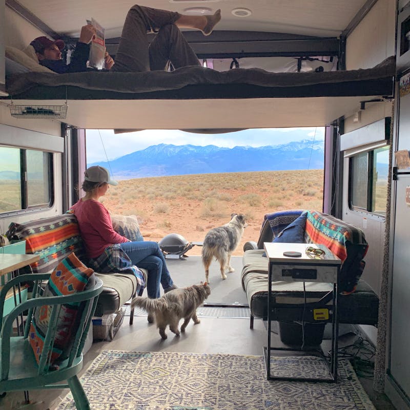 Amy Rekart looks out the back of her Cruiser Stryker toy hauler while her husband reads on the above bunk.