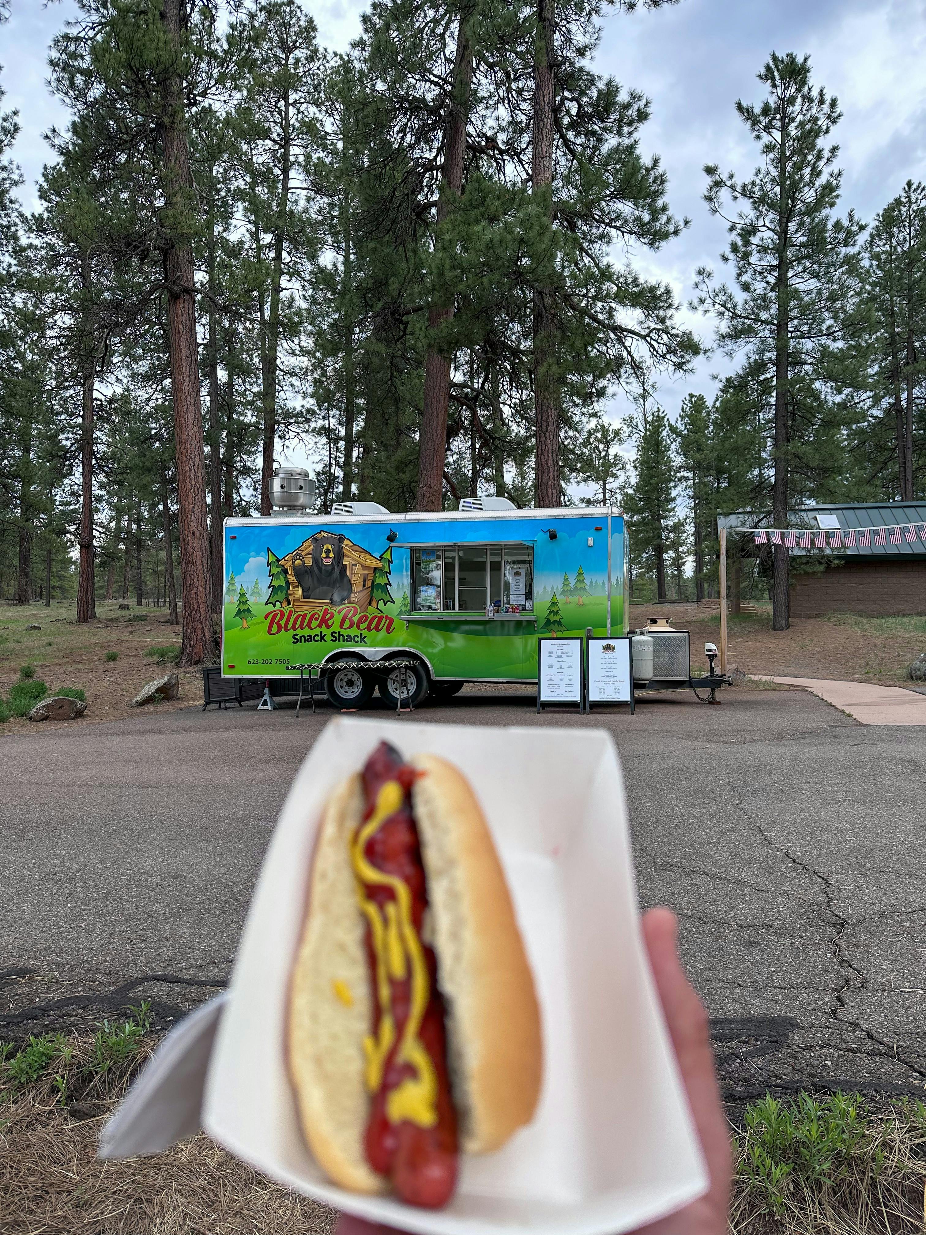 Jeff Poe holding up a hot dog in Kaibab National Forest