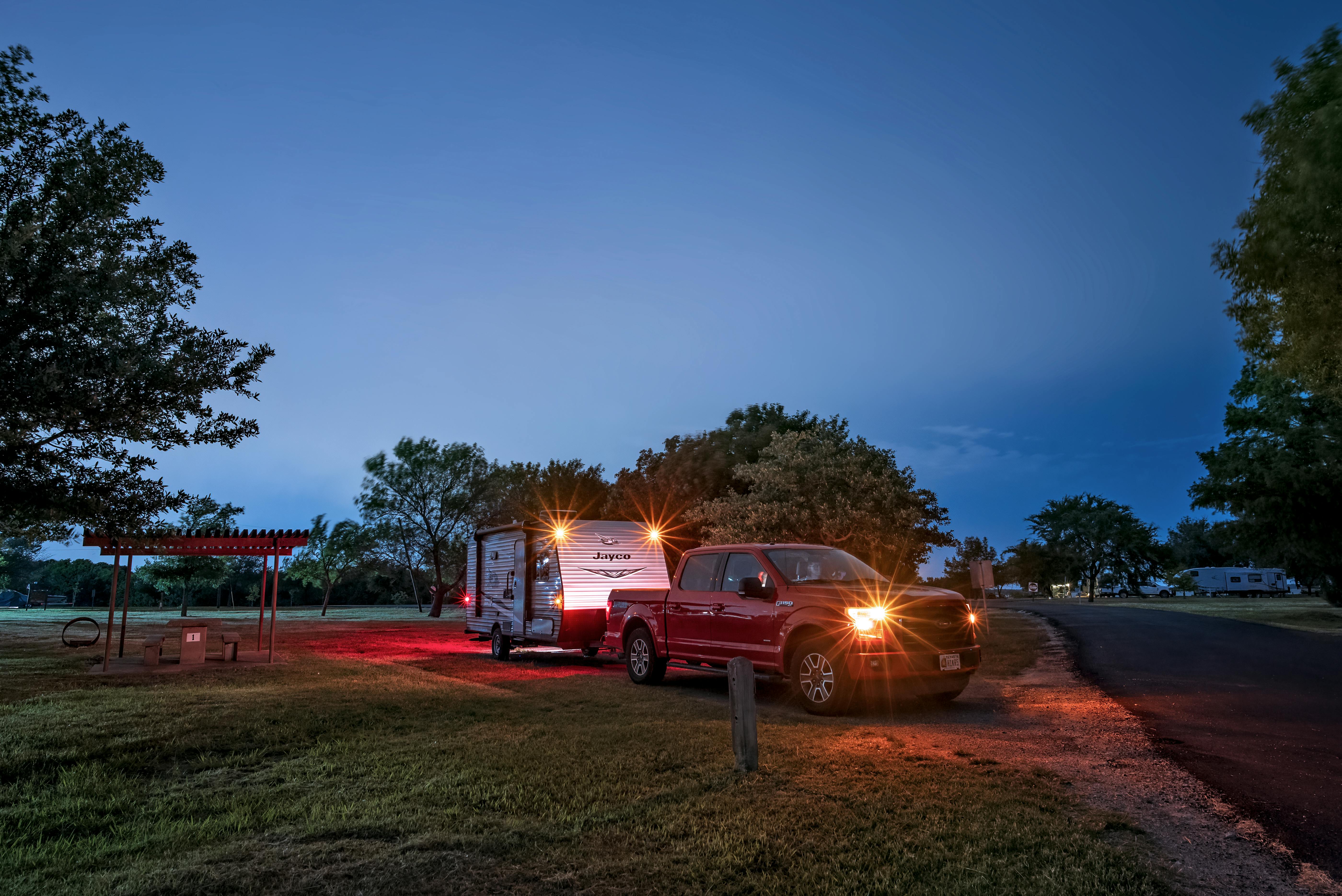 Jason Takacss parking his vehicle and jayco travel trailer at a campsite at night