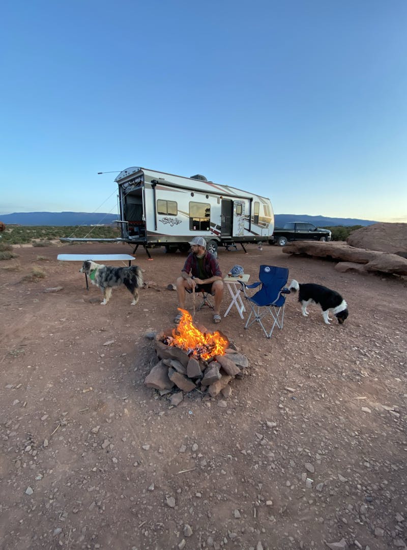 Amy Rekart's husband Mathew sits by a bonfire in front of their Cruiser Stryker toy hauler.