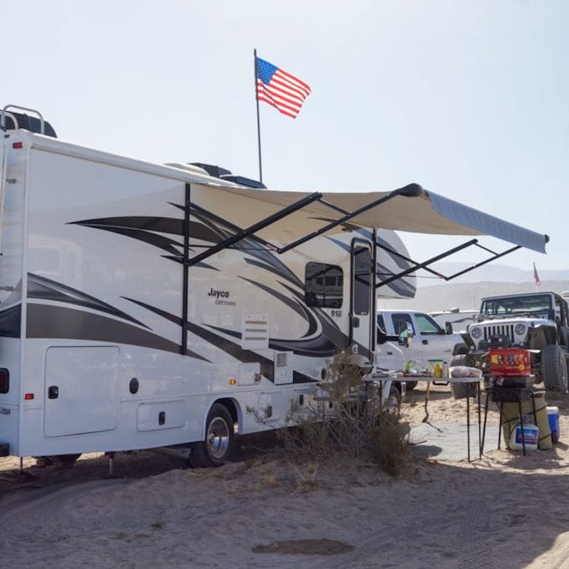 A Jayco RV parked with an American flag in the wind.