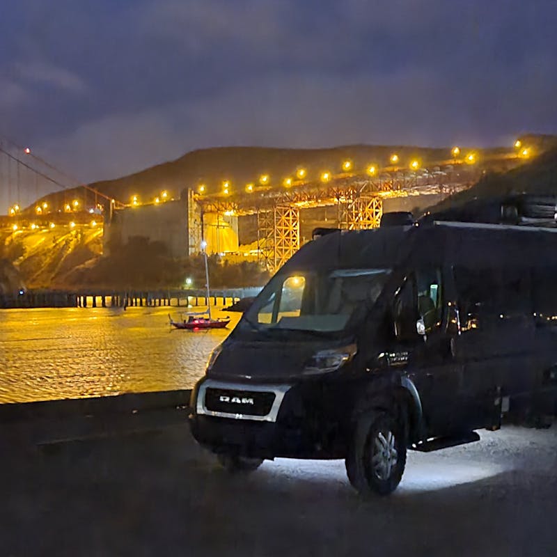 Gabe and Rocio's Class b campervan parked by scenic bridge