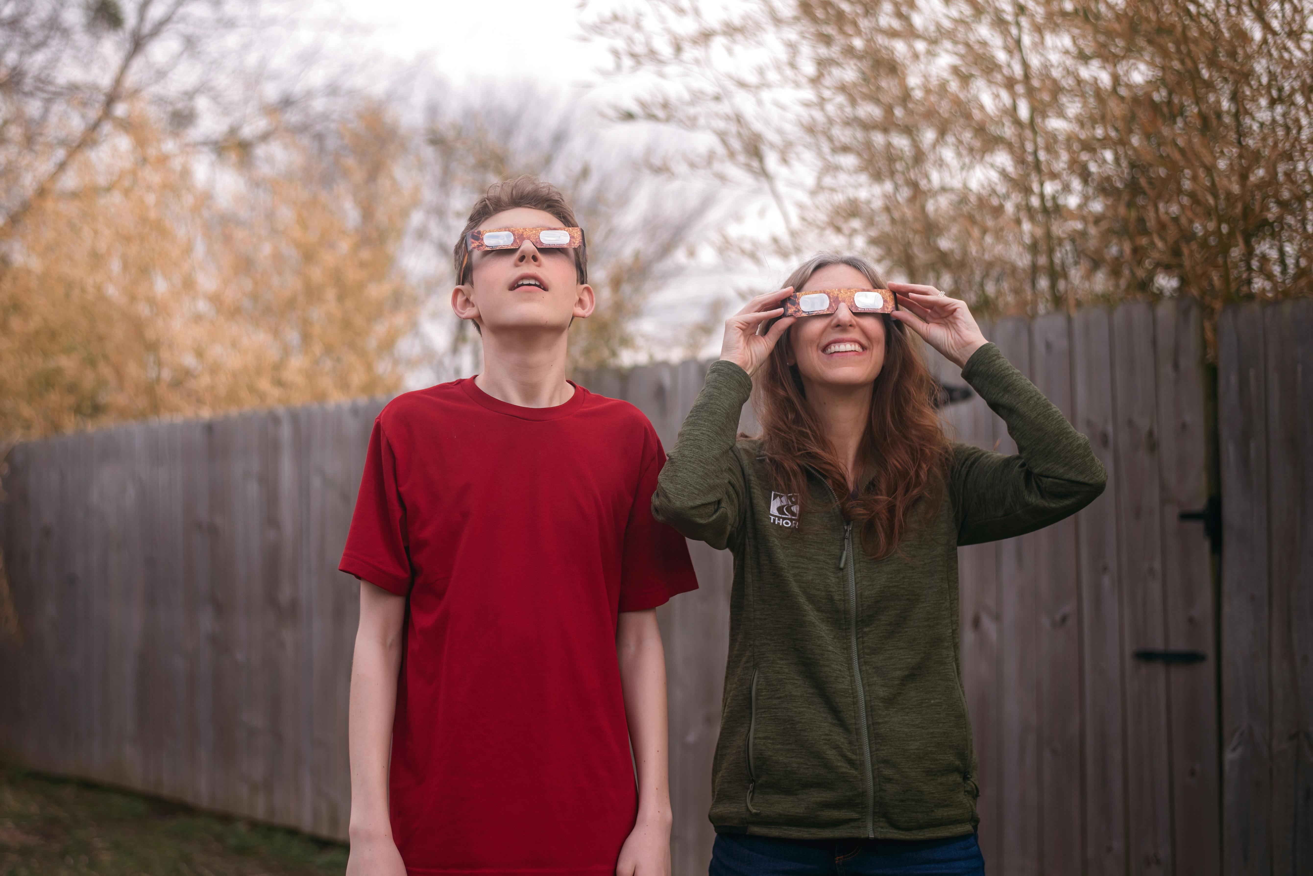 Alison Takacs using solar glasses with her son 