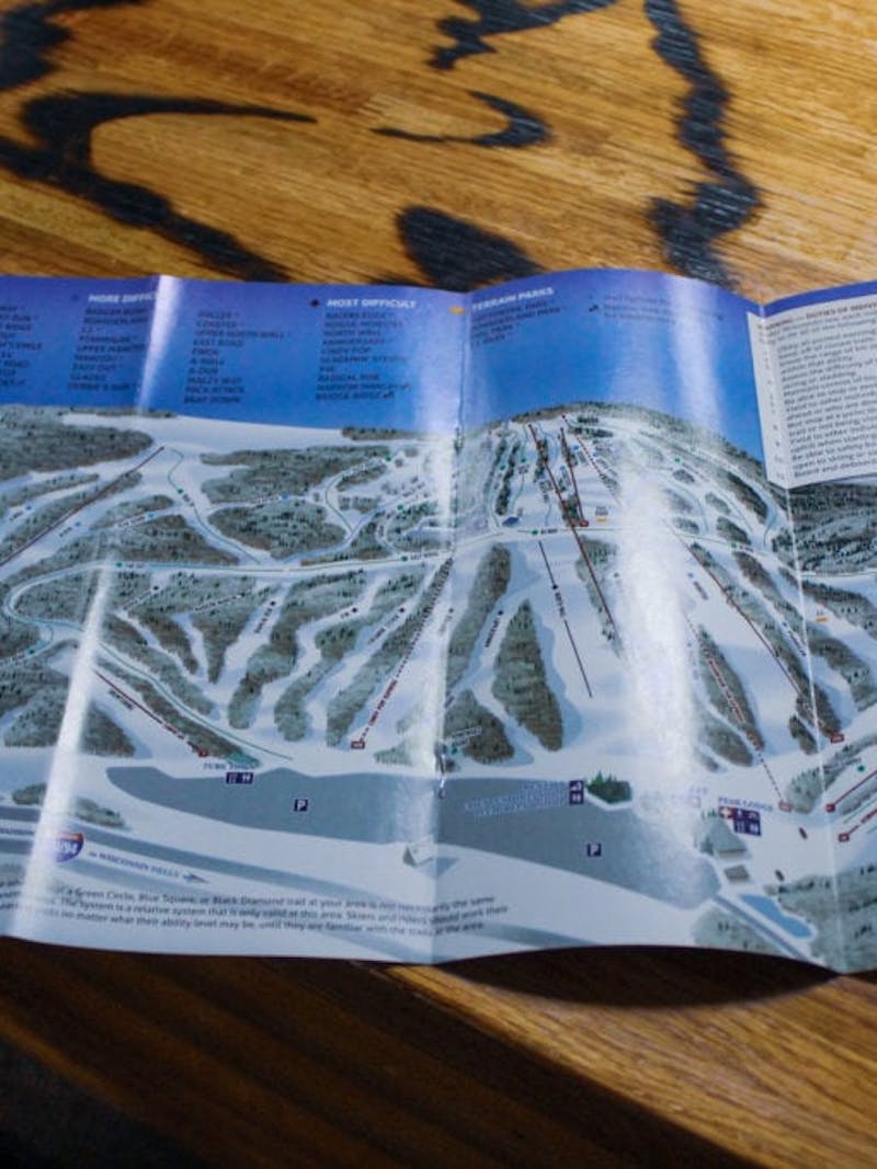 Map of Cascade Mountain Ski Resort, with all runs and lifts, on wooden surface