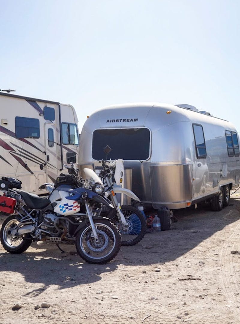 An Airstream and a couple of dirt bikes.