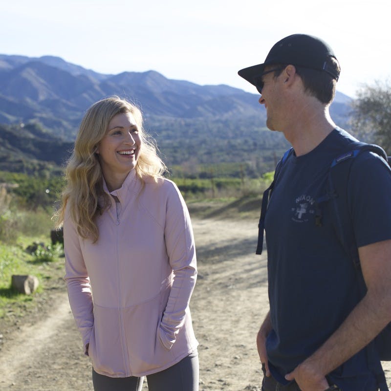 Sarah Schulz looking at her husband and smiling while on a hike in the mountains.