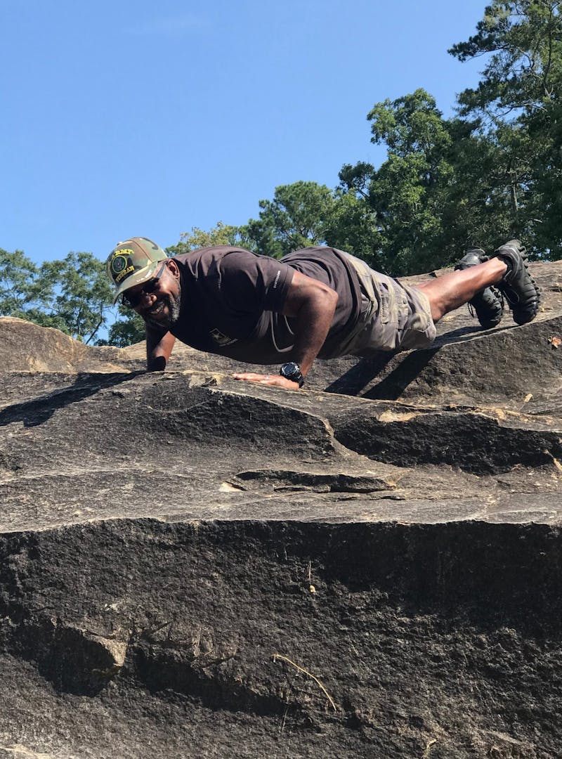 Mack Womack doing a pushup while on a hike.