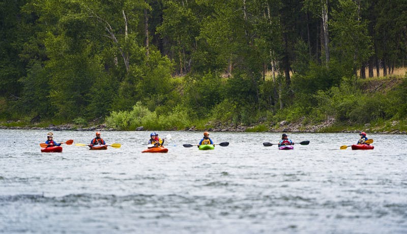 A wide shot of the participants kayaking in the Blackfoot River.