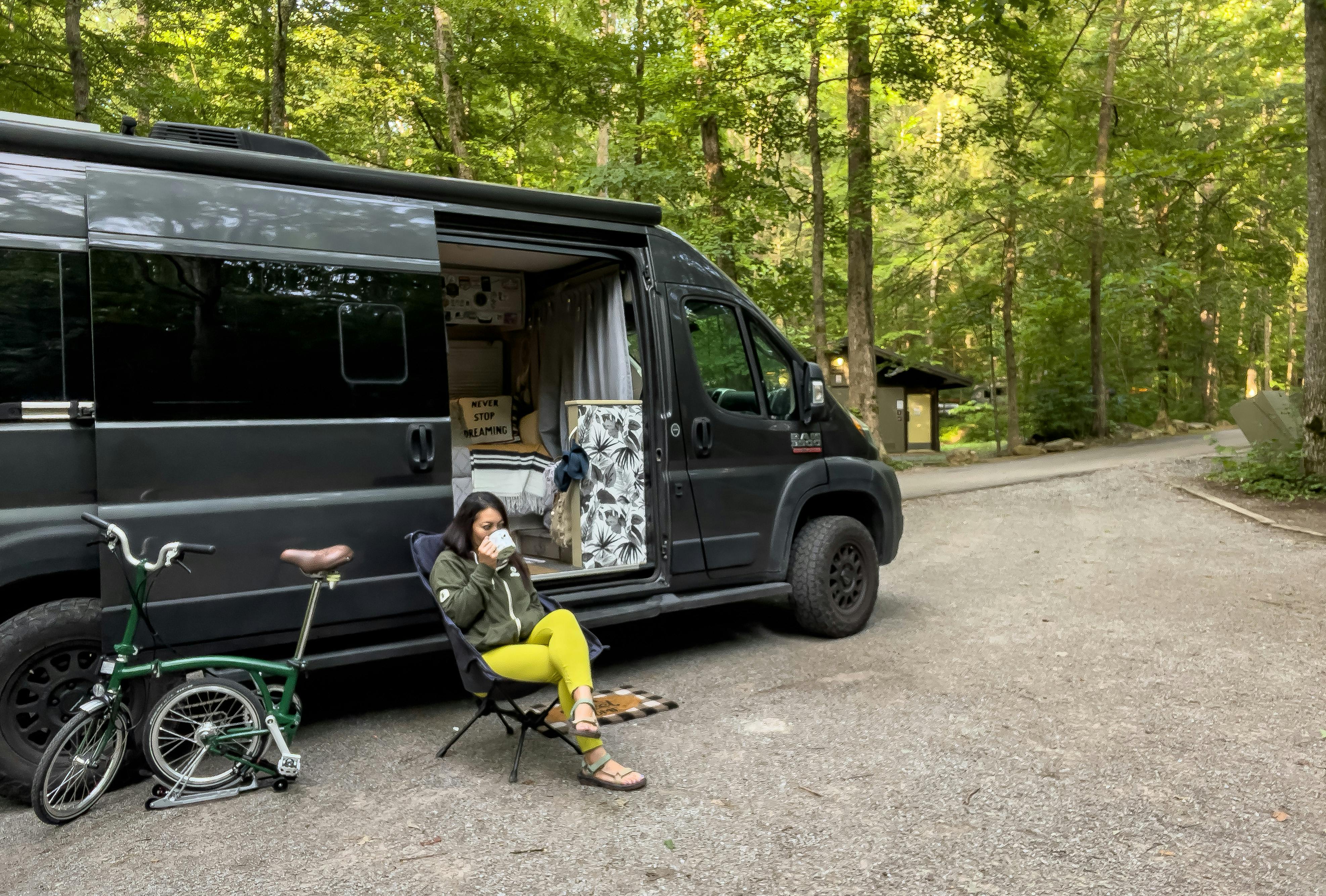 Jess Lawson sitting outside of her camper van at her campsite in Cherokee National Forest 