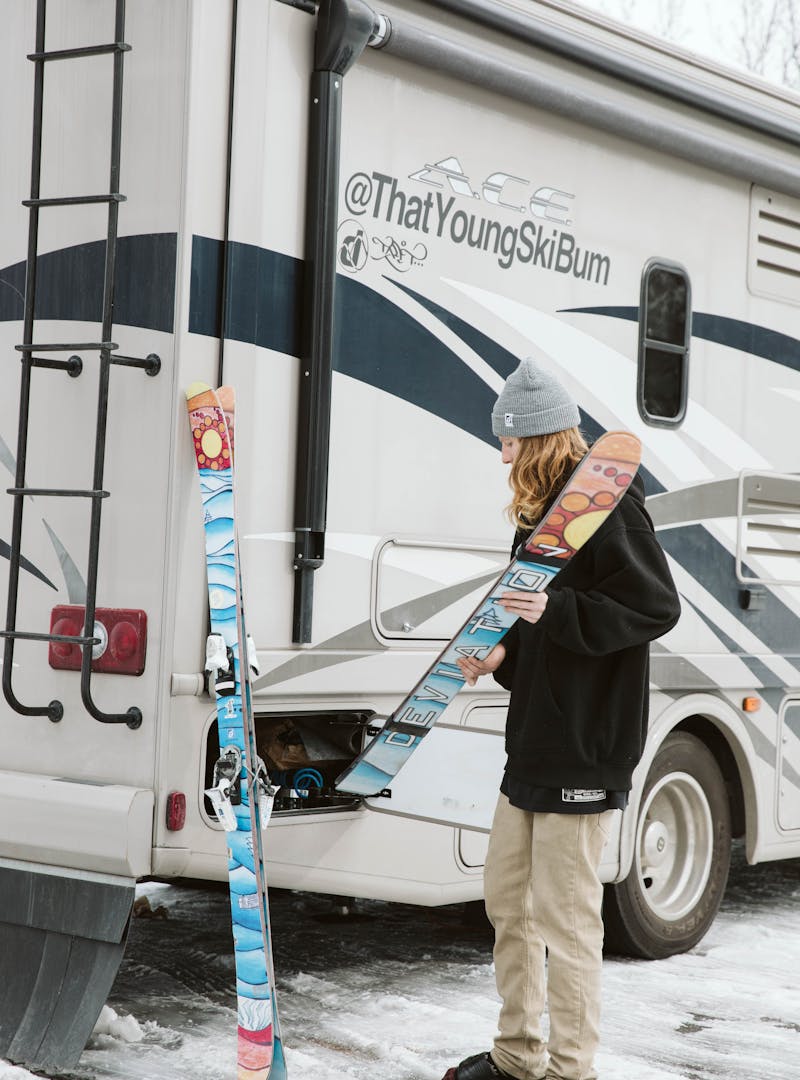 Packing skis into outside cubbies in an RV.