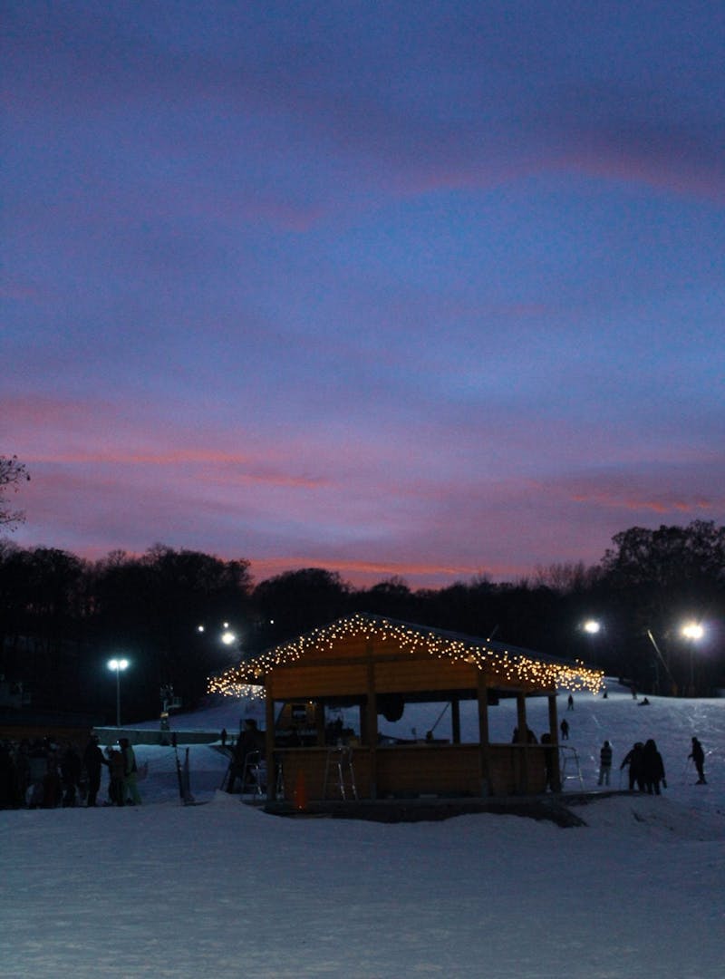 Cascade Mountain ski lodge with lights and snow with a sunset