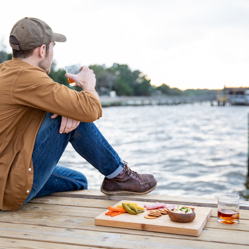 Jon drinking a Sazerac cocktail at the end of a dock.