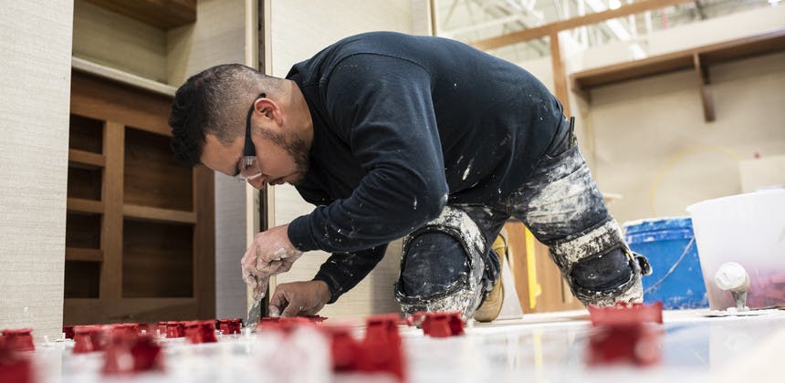 Worker hand tiling floor of Entegra Coach RV