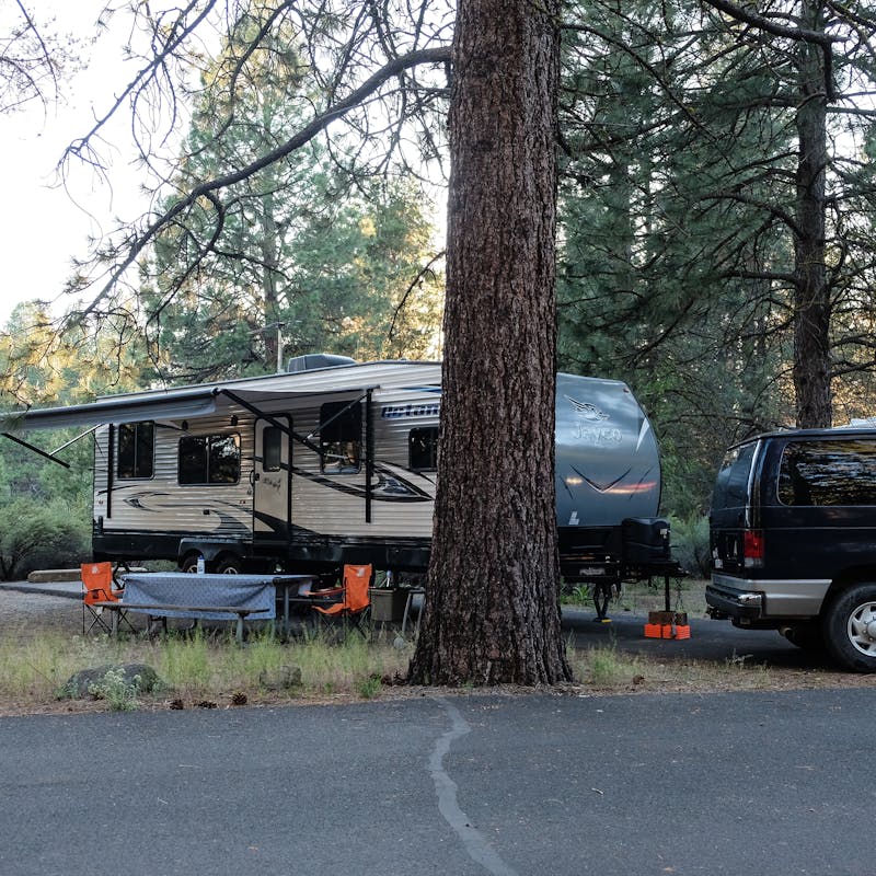 Gretchen Holcomb's Jayco Octane toy hauler parked in a wooded campsite.