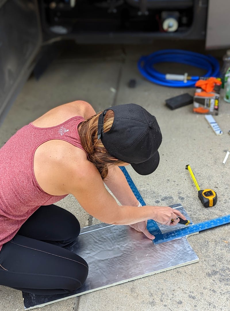 Sarah Bauer measuring and cutting insulation for her RV