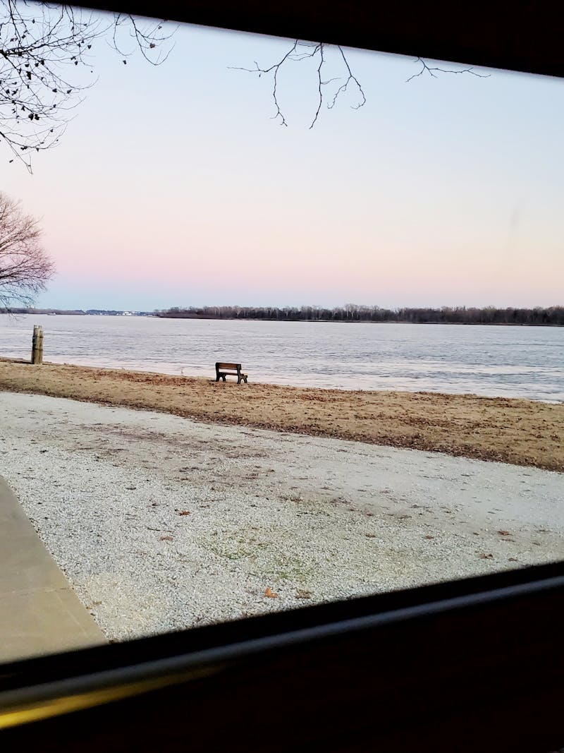 A photograph out an RV window onto a wintry lake.