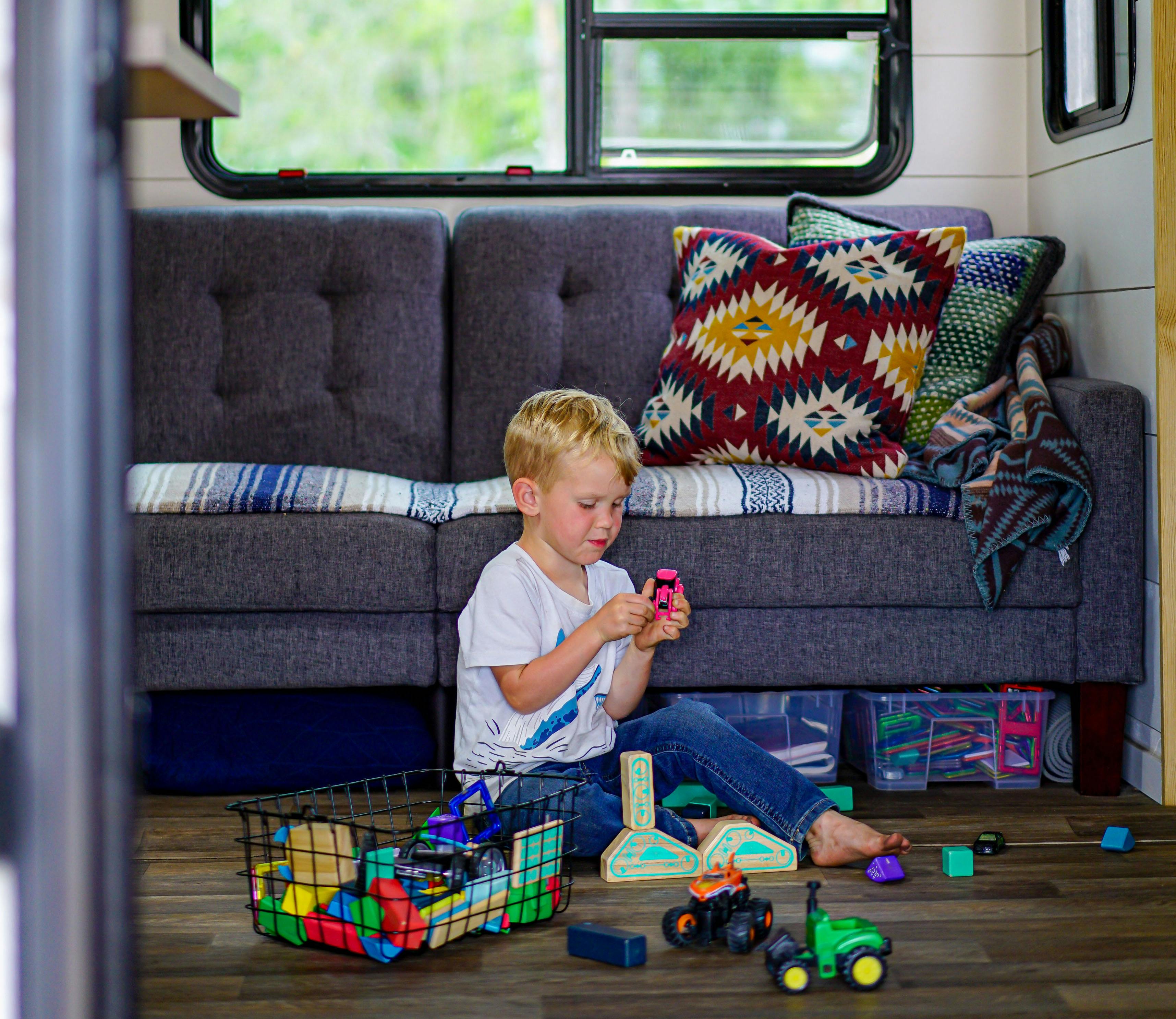 Renee Tilby's child playing in their jayco travel trailer with blocks and other toys