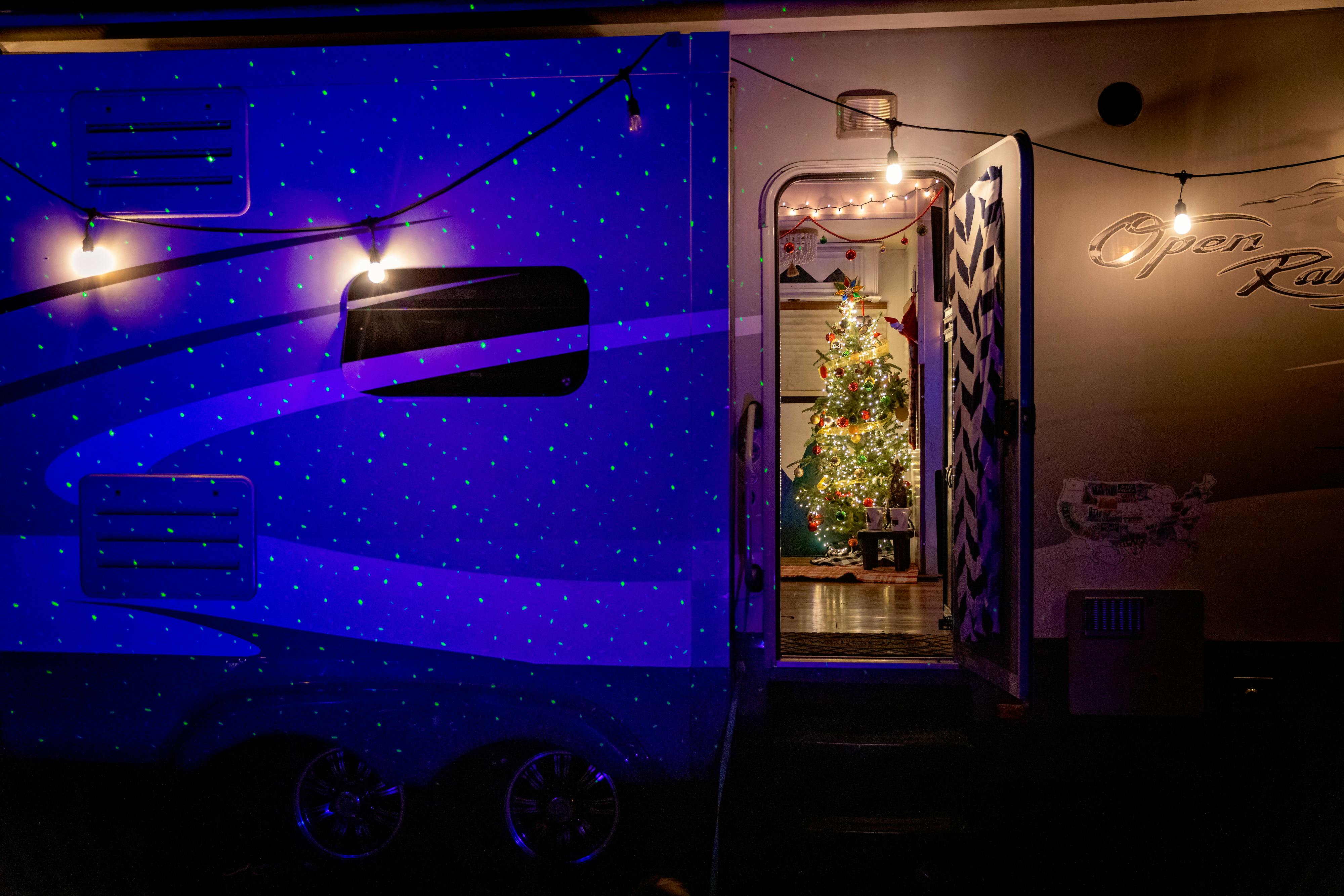 JOSH & CASSIE BAILEY's RV door open showing a lit up christmas tree inside
