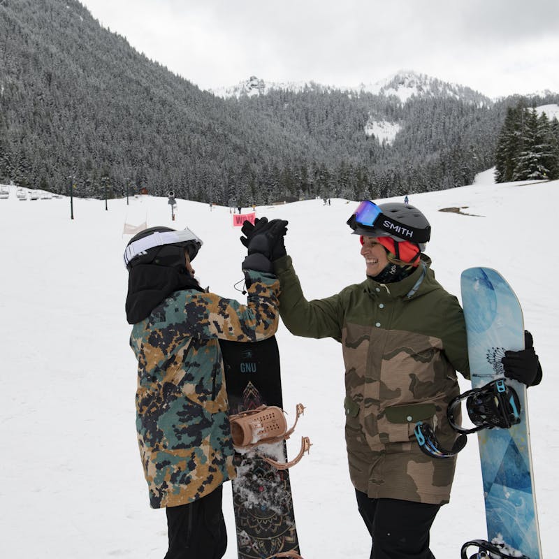Chelsea and Layla high fiving while surfing