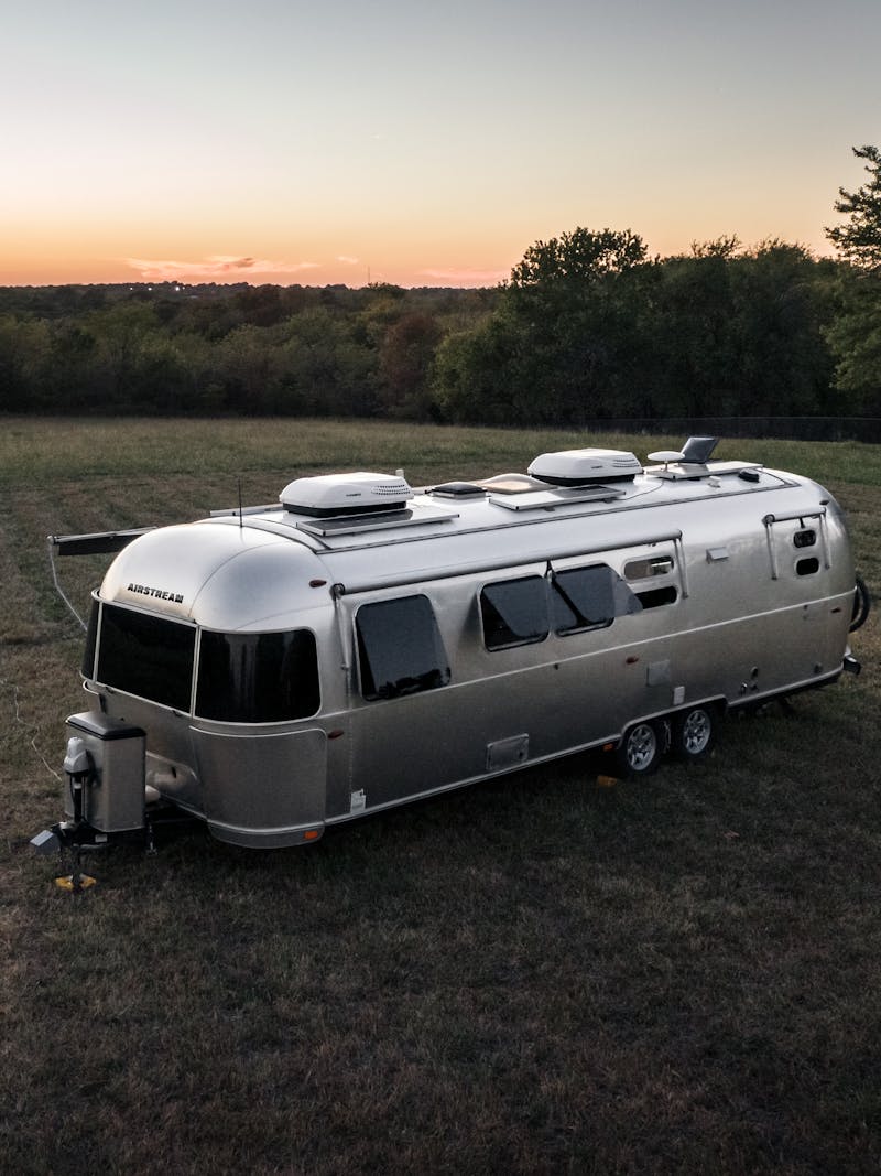 Karen Blue's airstream boondocking in a field at dusk