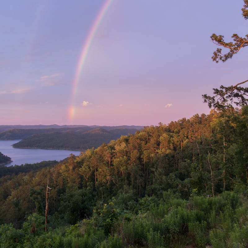 A Brilliant Rainbow at Sunset over Mountain Lake in Beavers Bend State Park