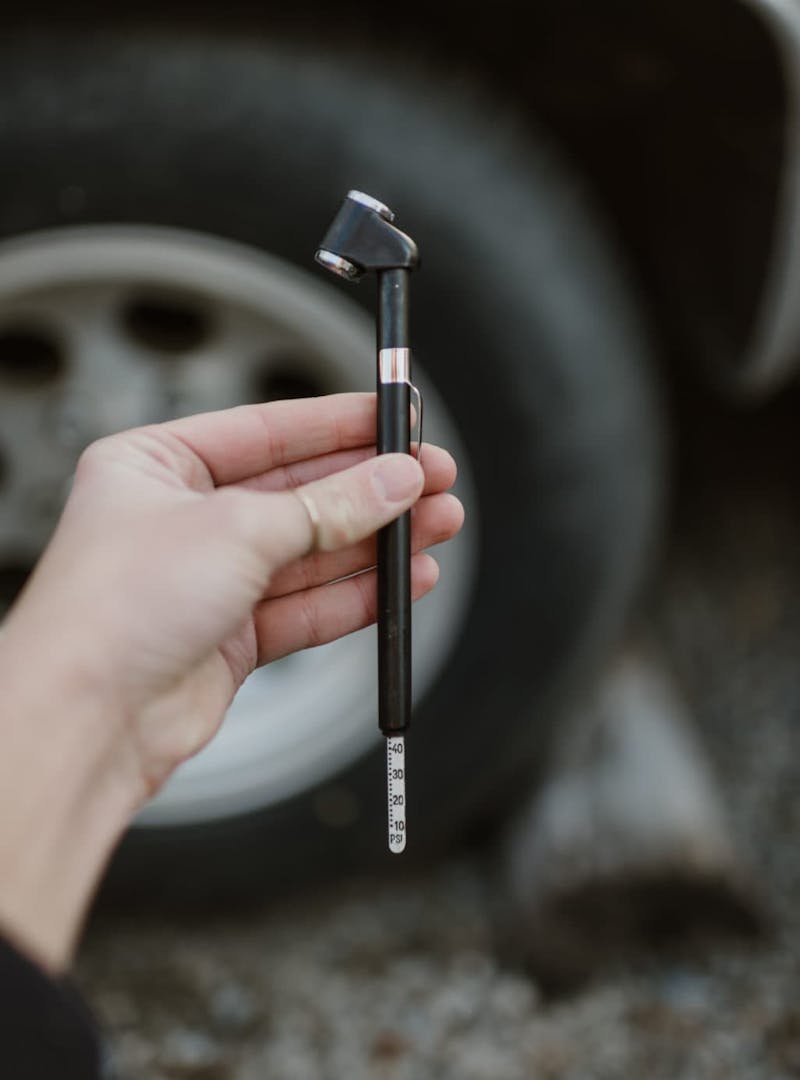 Close up of hand holding a tire pressure gauge
