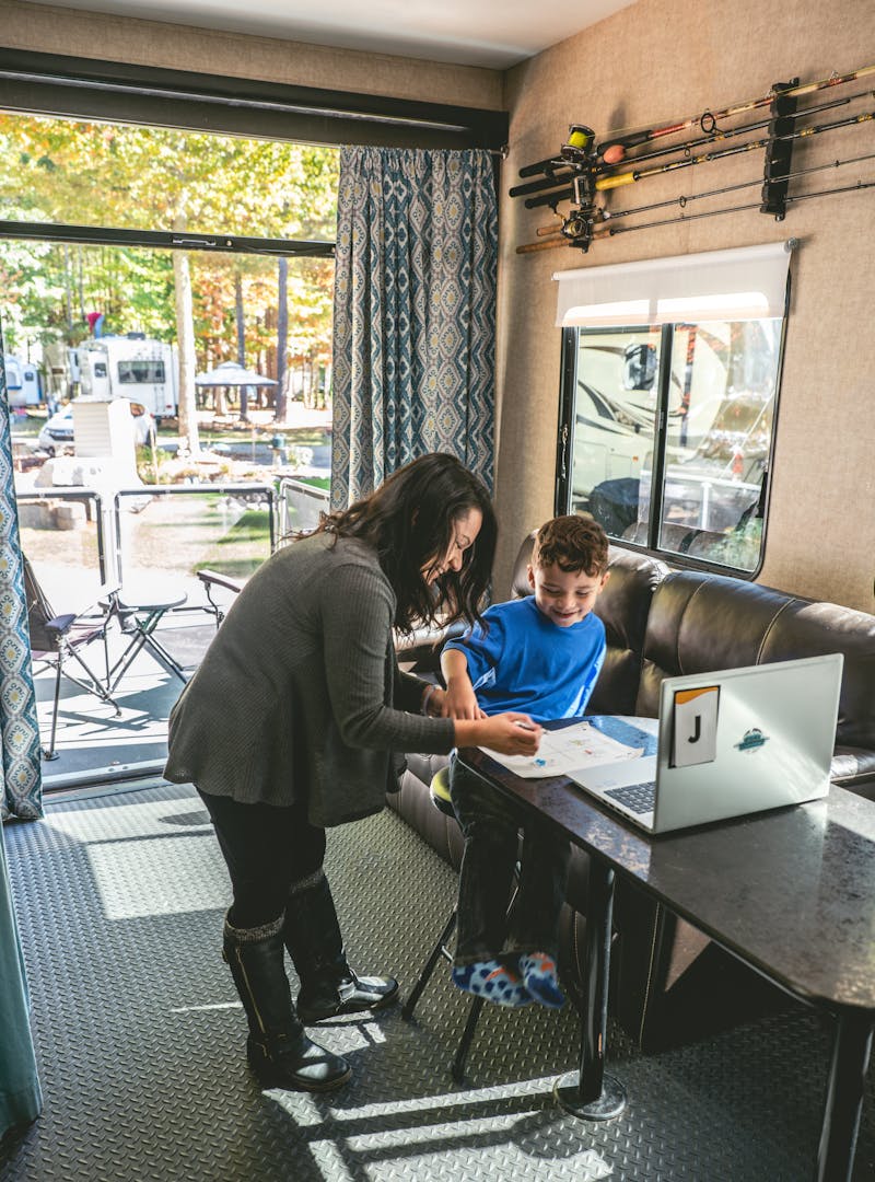 Sandra standing over her son at a desk in the converted garage space.