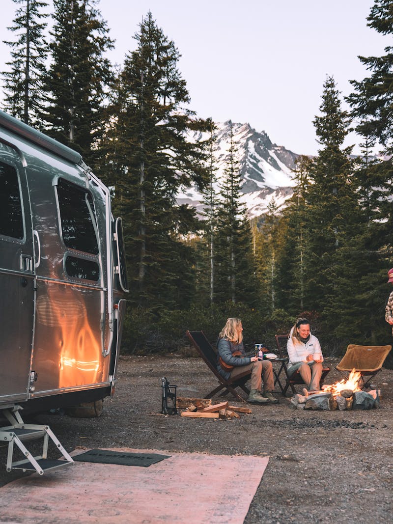 Karen Blue and her family sitting around a fire while boondocking in a forest