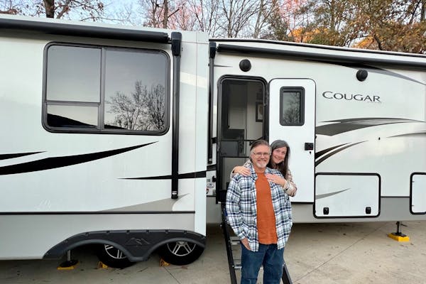 Donny and Tammy Benedict pose outside of their Keystone Cougar.