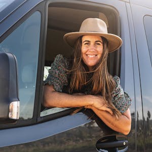 Sarah Glover smiling out of the window of a TMC Tranquility camper van.