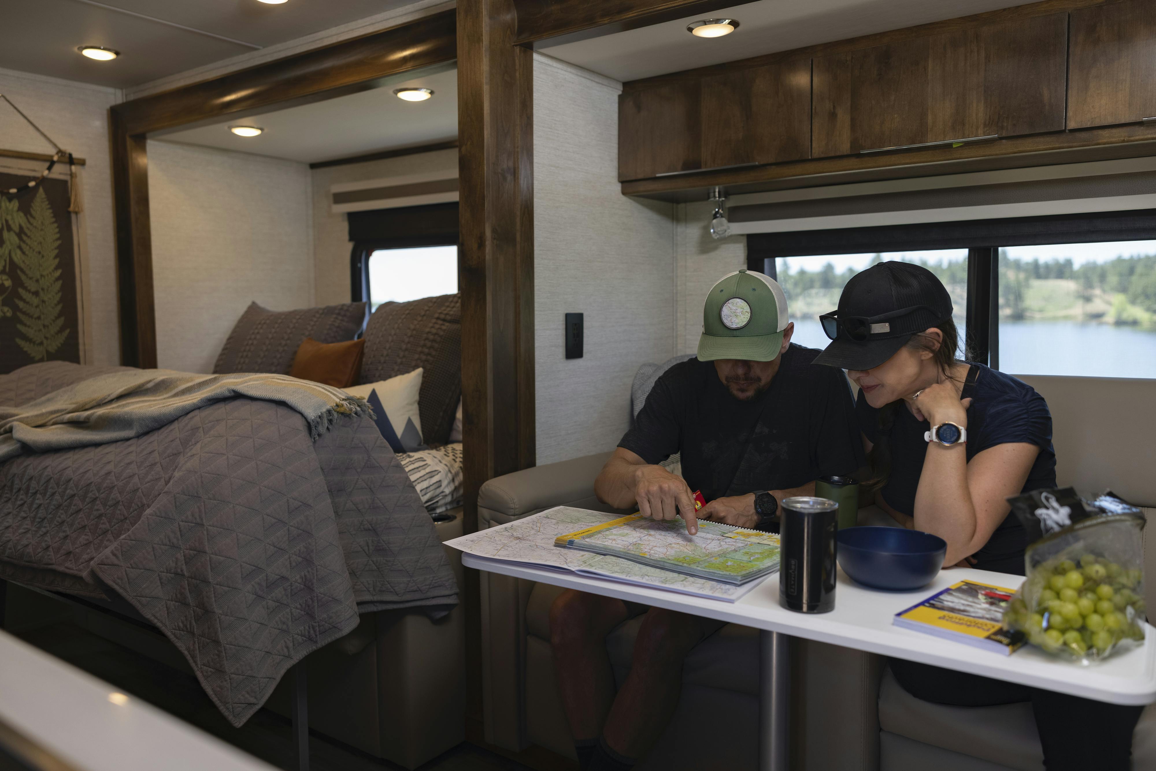 Dustin and Sarah look at a map sitting in the dinette inside their Tiffin Wayfarer