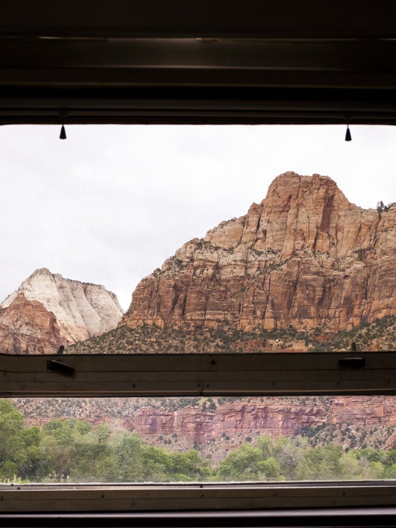 A beautiful view from inside an RV looking out the window to the mountains at Zion National Park.