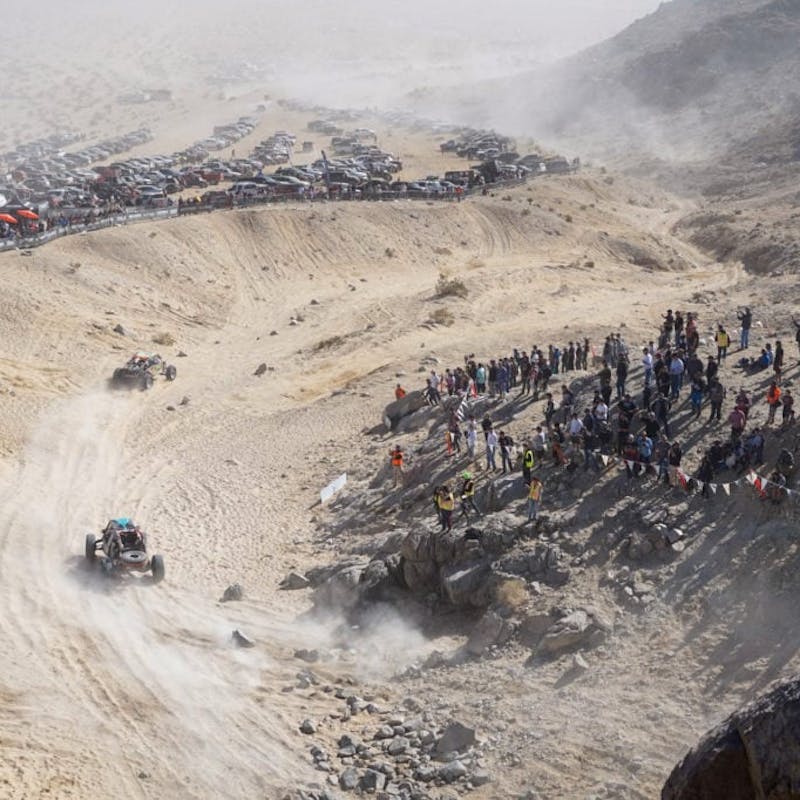 Ultra4 vehicle rounding a section of the path while spectators watch.