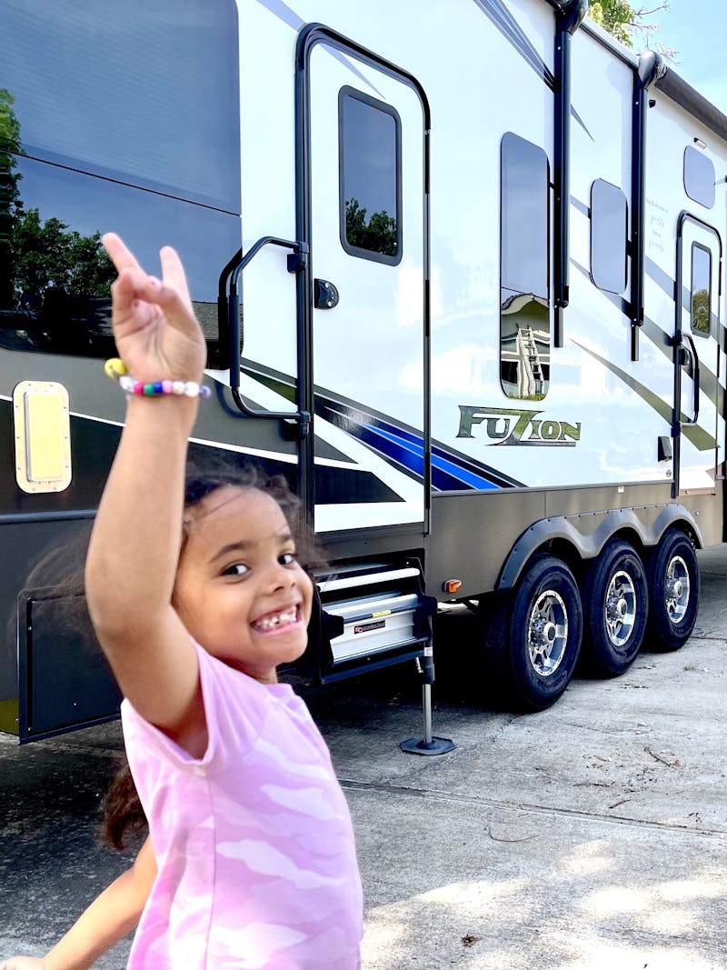 Robin and Warren Baxter's granddaughter throwing up a peace sign in front of their RV
