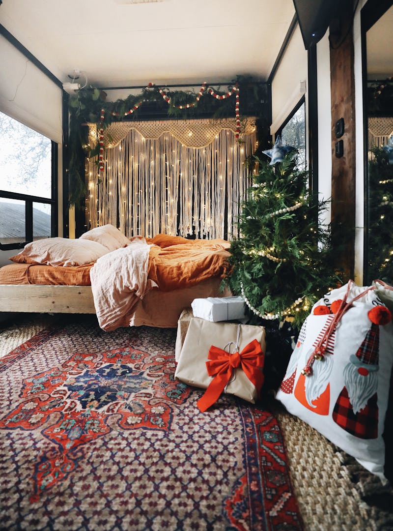 Christmas lights and a tree with gifts around it in the master bedroom.