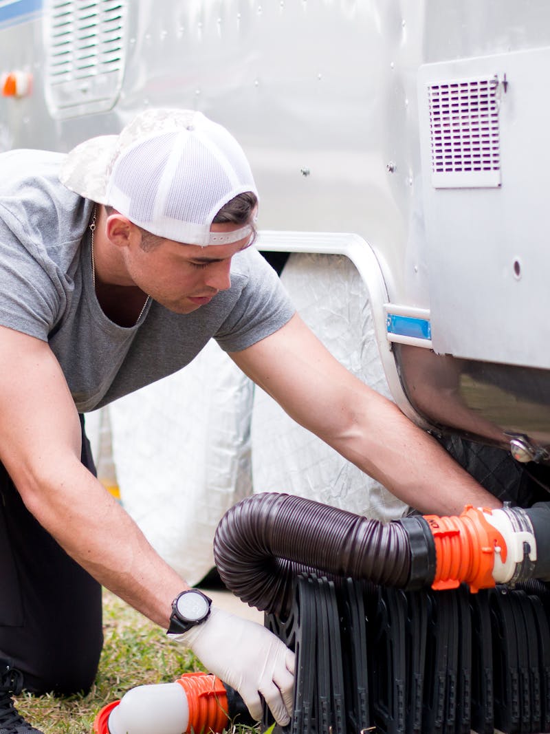 a man dumping his black water tanks while wearing gloves