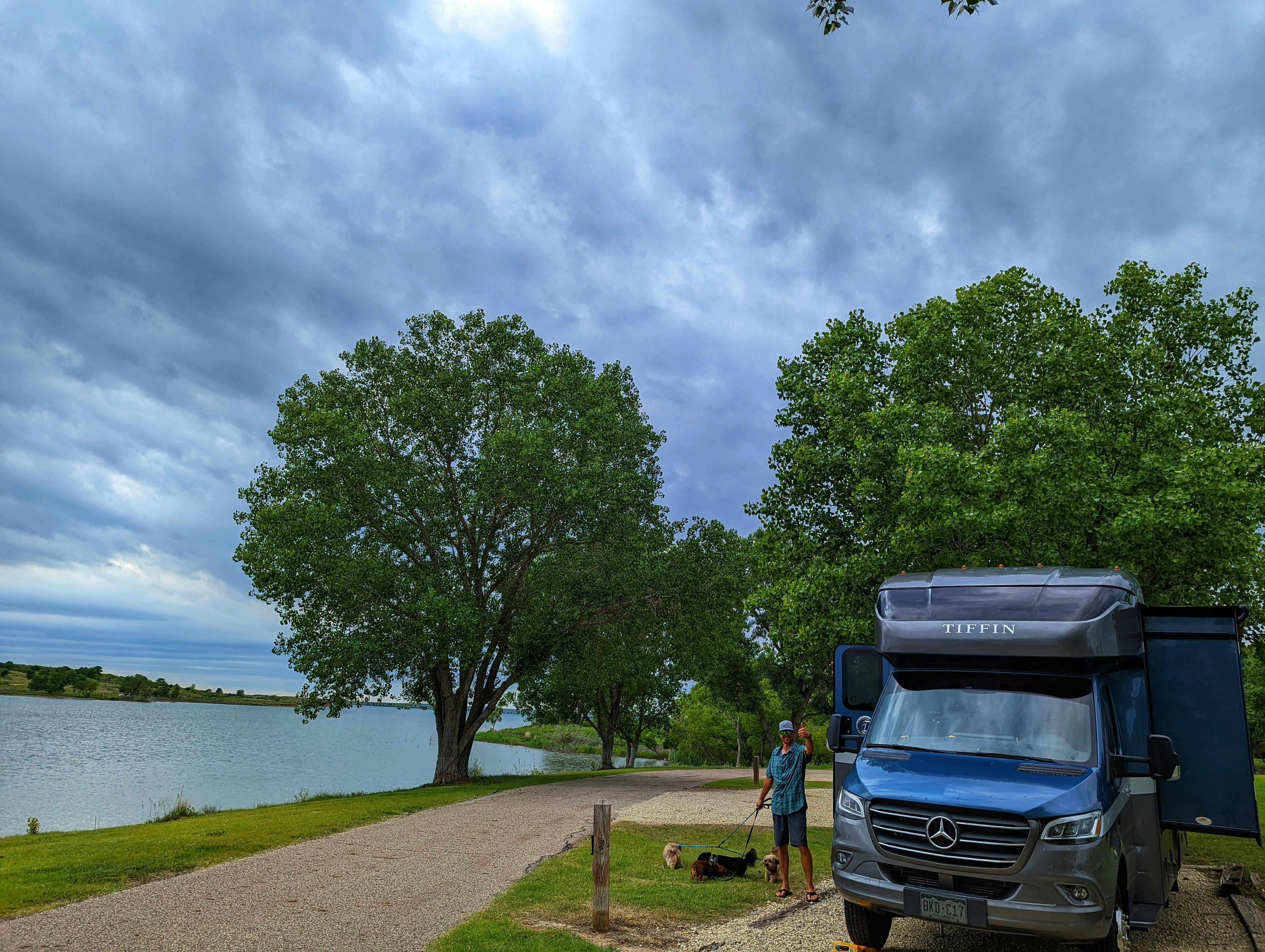 Dustin and Sarah Bauer's RV parked at a campsite next to a lake 