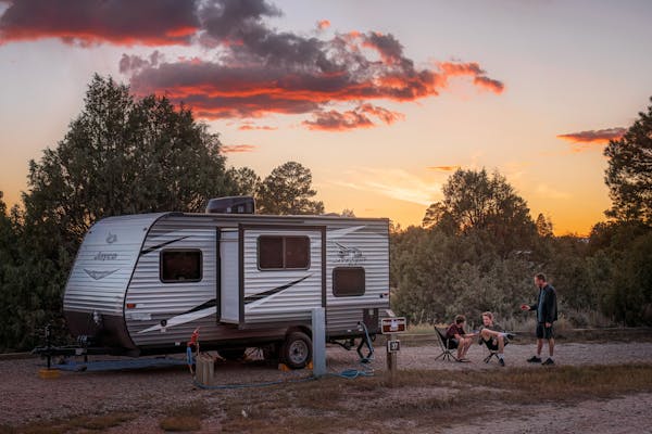 The Alison and Jason Takacs family outside of their Jayco Jay Flight during sunset