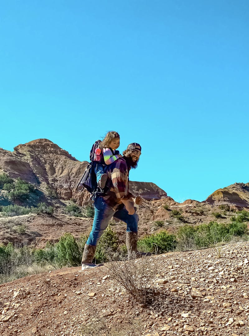 Sammy Seles' husband on a hike with their two year old daughter on his back.