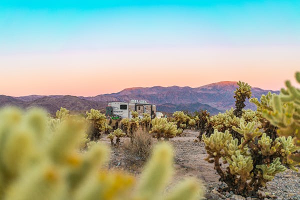 Renee Tilby's RV parked by mountain dessert at sunset