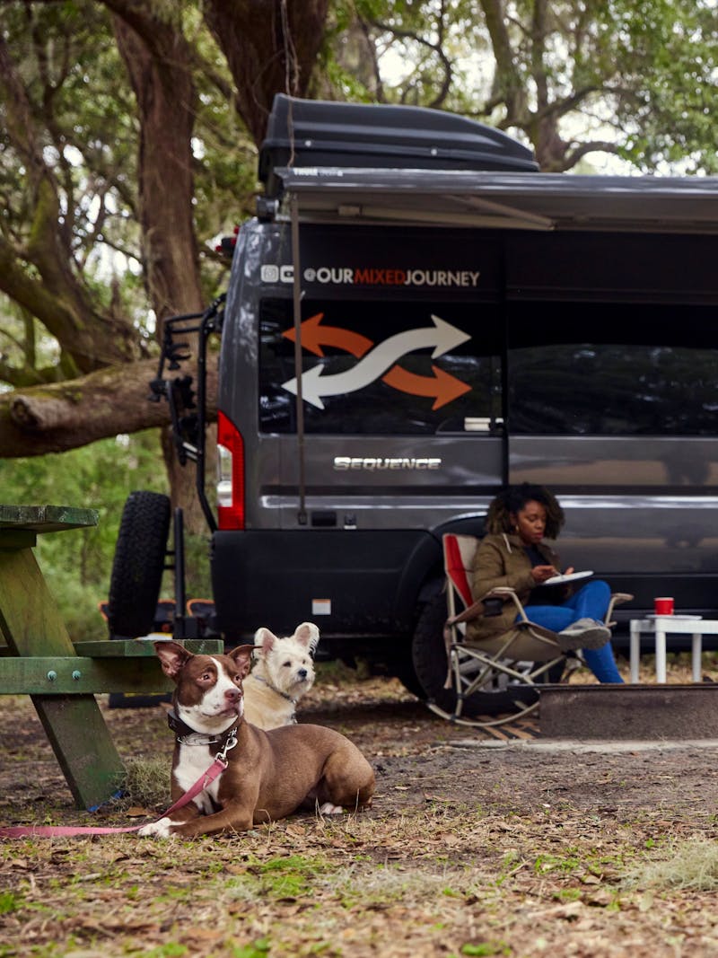 Gabe and Rocio Rivero sitting outside their RV with their two dogs