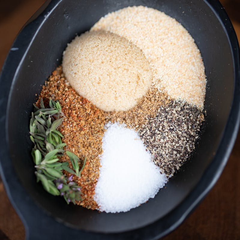 A bowl of herbs and spices in pretty piles in a bowl.