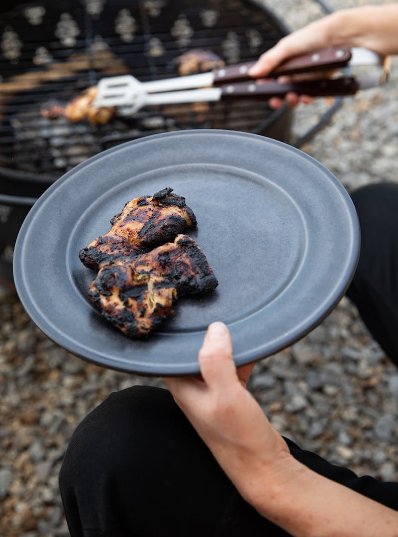 Crispy BBQ chicken being taken off the grill.