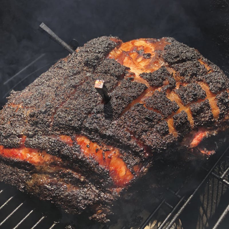 Pork smoking in a smoker.