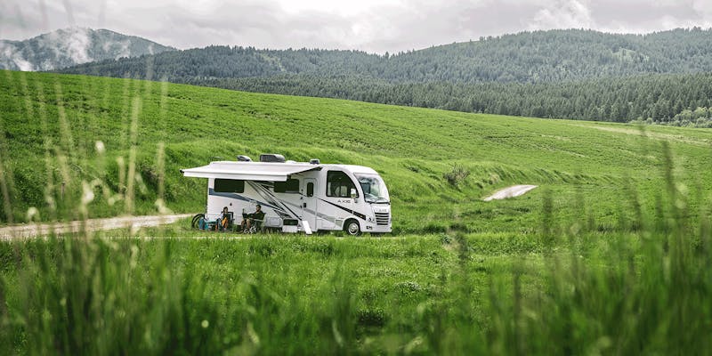 2024  Axis Class A Motorhome in open grassy area with woods and mountains behind